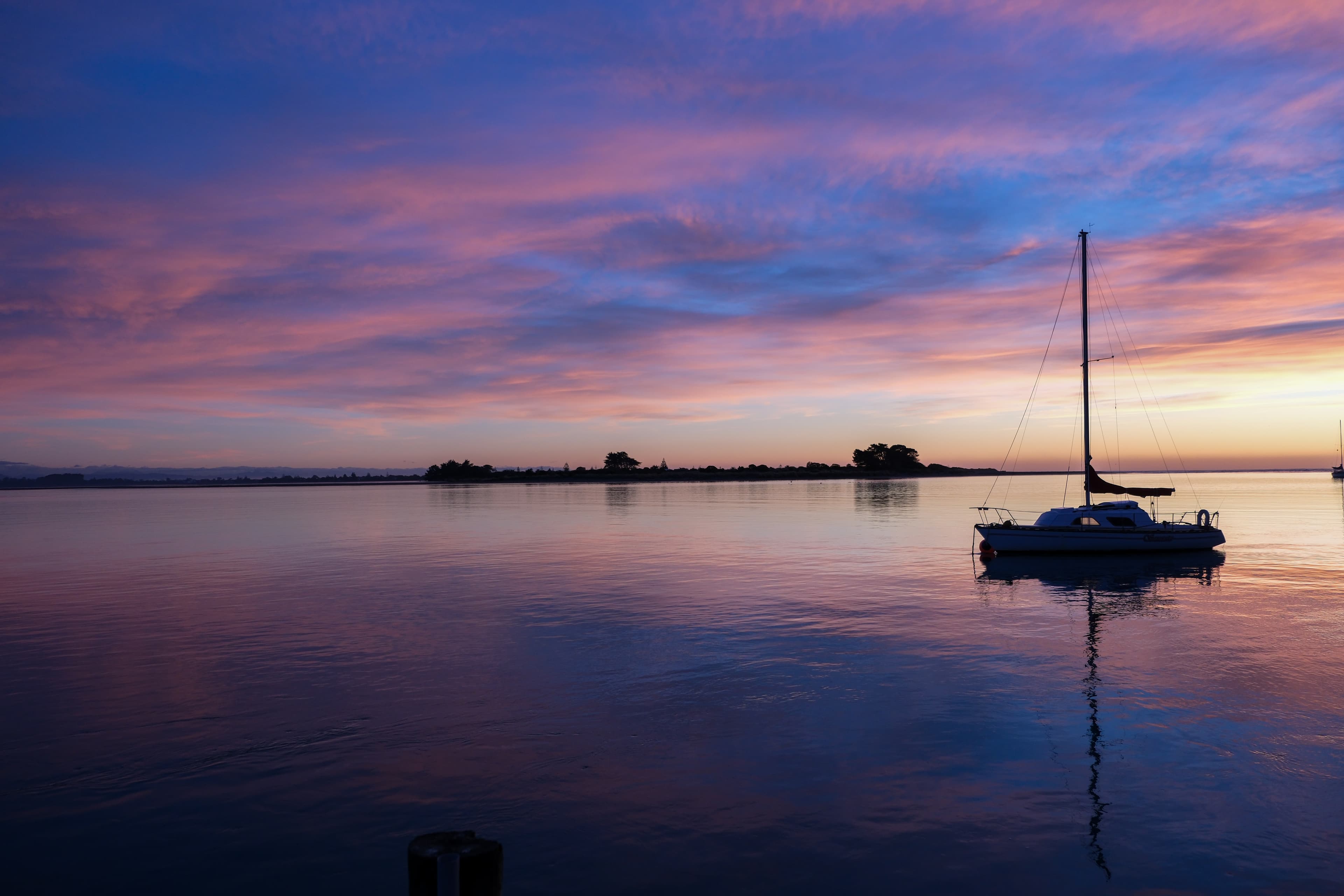 18mm · f/2.8 · 1/400s · ISO 400
FUJIFILM X-T5 · XF18-55mmF2.8-4 R LM OIS · May 24, 2024
Sailboat on calm Christchurch water beneath a colorful sunrise sky.
Christchurch, New Zealand
© Brandon Cook